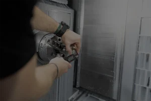Machinist using digital calipers at a CNC lathe chuck to verify pitch diameter and setup before threading — Dallas Precision Machining CNC machine shop.